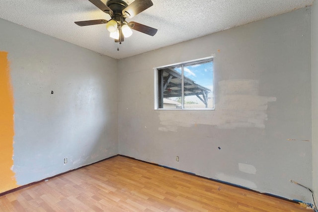 unfurnished room featuring a textured ceiling, light wood-type flooring, and a ceiling fan