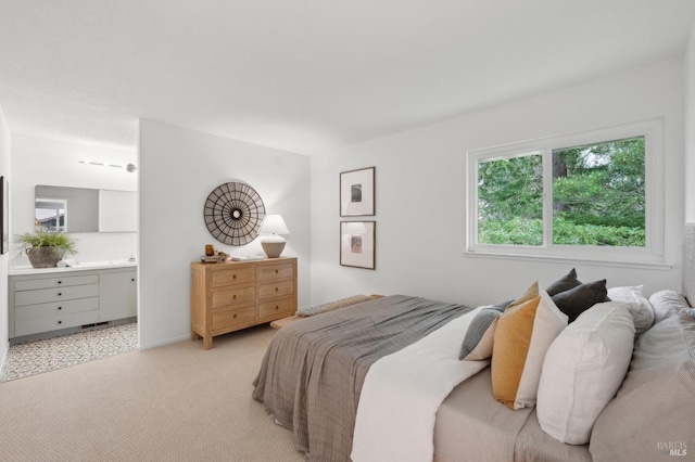 bedroom with light carpet and connected bathroom