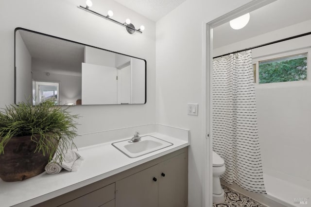 bathroom with toilet, a textured ceiling, a shower stall, and vanity