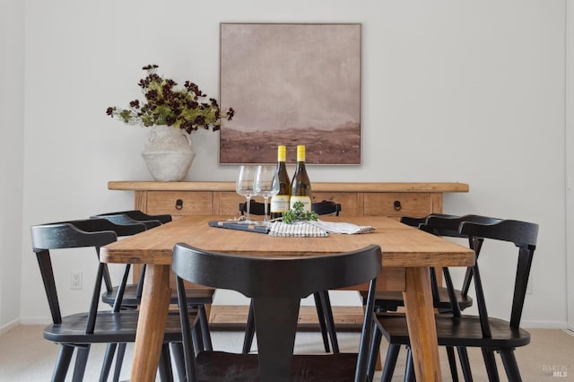 dining room featuring carpet floors and baseboards