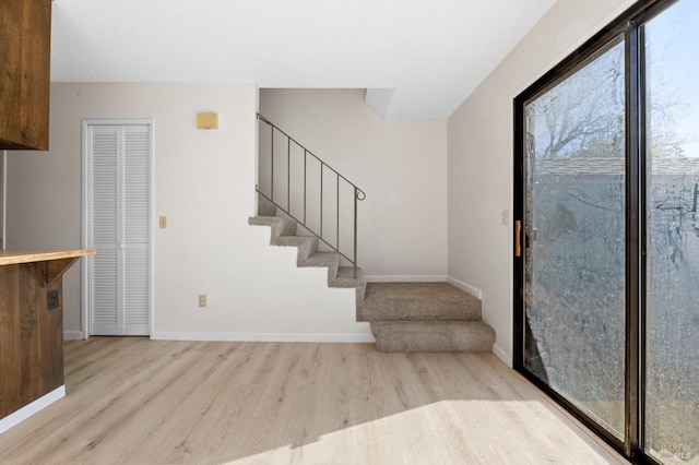 entrance foyer featuring stairway, baseboards, and wood finished floors