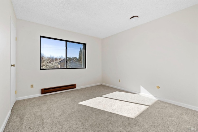 spare room with carpet, baseboards, baseboard heating, and a textured ceiling