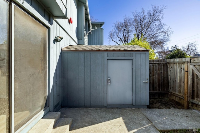 view of shed featuring fence