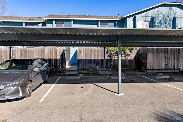 covered parking lot featuring fence