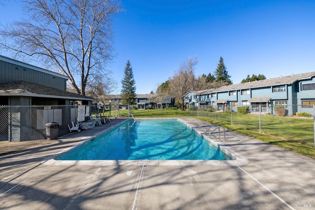 view of pool with a yard, fence, a residential view, and a fenced in pool