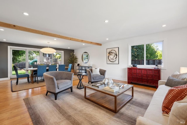 living room with plenty of natural light, recessed lighting, beamed ceiling, and light wood finished floors