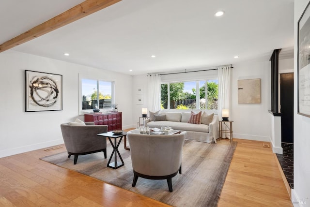 living room with light wood-style floors, recessed lighting, beam ceiling, and a wealth of natural light