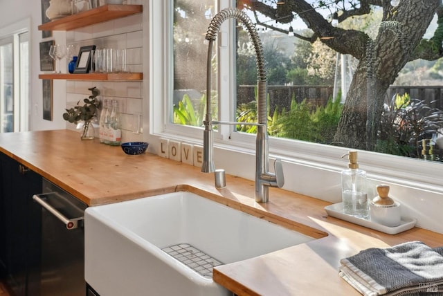 interior space featuring butcher block counters, open shelves, and a sink