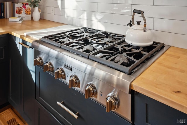 room details with butcher block counters, range, and backsplash