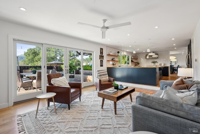 living room with recessed lighting, french doors, plenty of natural light, and light wood finished floors