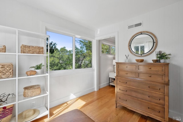 sitting room with a wealth of natural light, visible vents, and wood finished floors