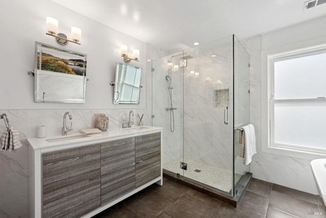 full bath featuring a sink, visible vents, and tile walls