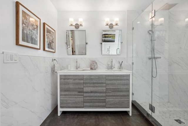 full bath with a sink, tile walls, and a marble finish shower