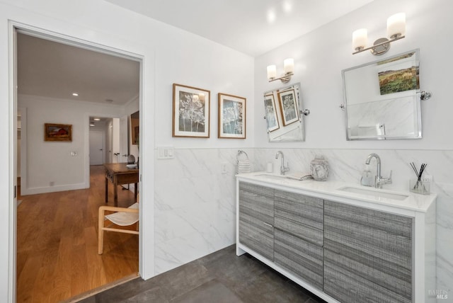 full bathroom featuring ornamental molding, a sink, tile walls, and double vanity