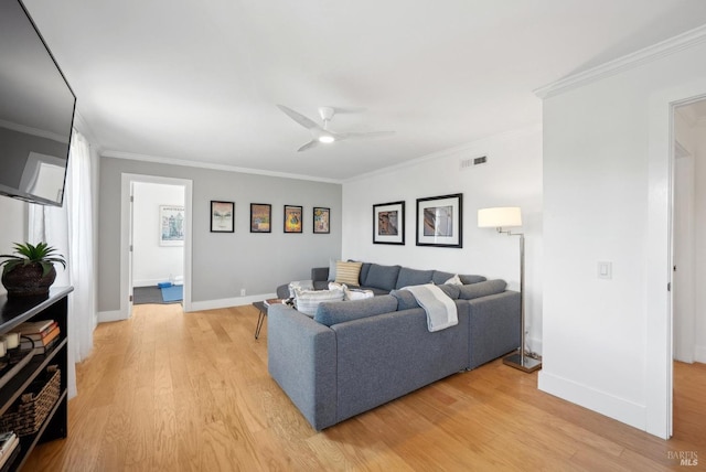 living area featuring light wood-style floors, visible vents, ornamental molding, and baseboards