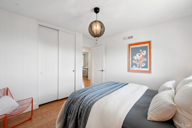 bedroom with a closet, visible vents, and light wood-style flooring