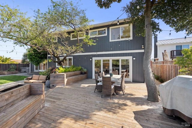 rear view of property with outdoor dining area, fence, a deck, and french doors