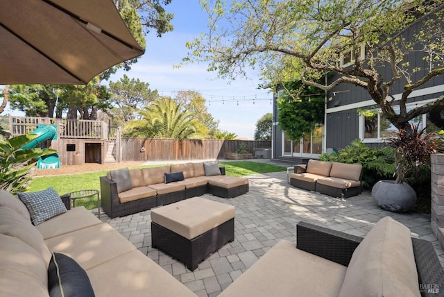 view of patio / terrace with a fenced backyard, outdoor lounge area, and a playground