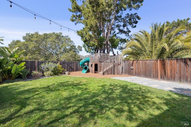 view of yard featuring a fenced backyard and a playground