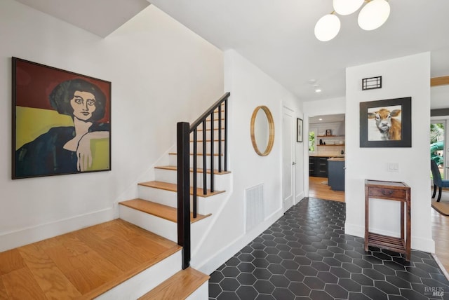 staircase with visible vents, baseboards, and tile patterned floors