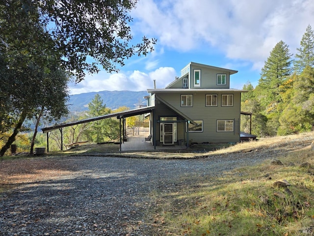 back of property featuring an attached carport and a mountain view