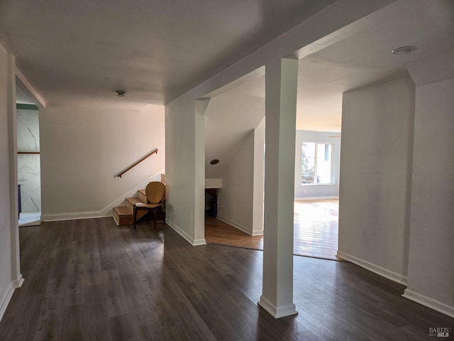 additional living space with dark wood finished floors, stairway, and baseboards