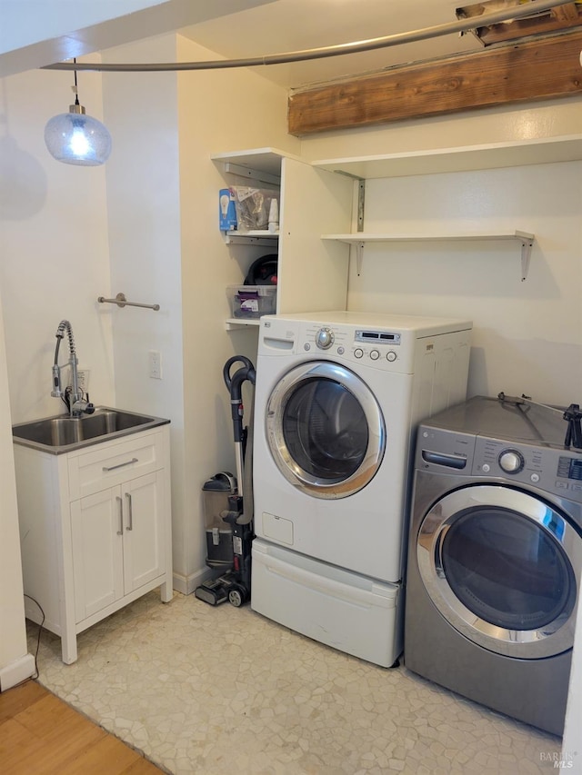 laundry room with independent washer and dryer and a sink