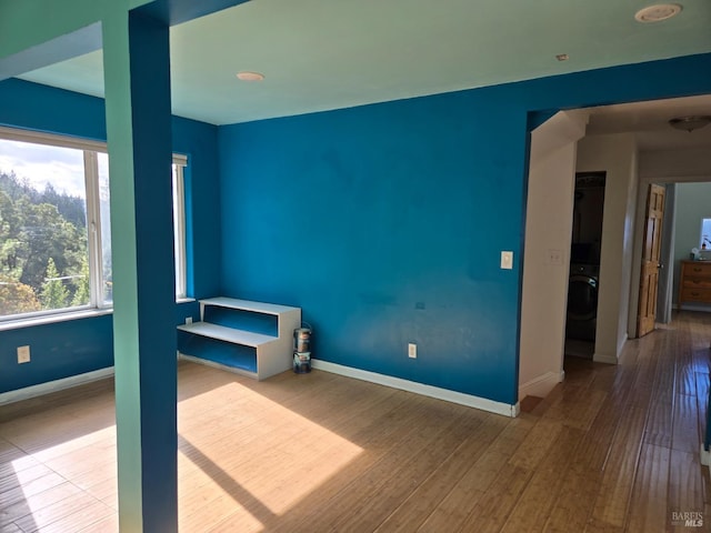 unfurnished room with wood-type flooring and baseboards