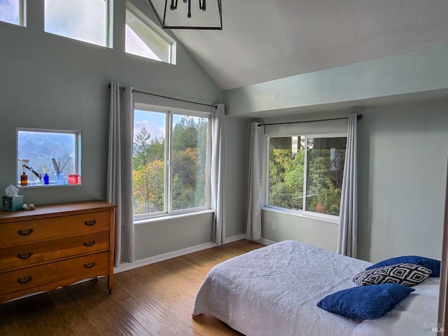 bedroom with lofted ceiling, wood finished floors, and baseboards