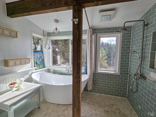 full bathroom with a freestanding tub and a tile shower