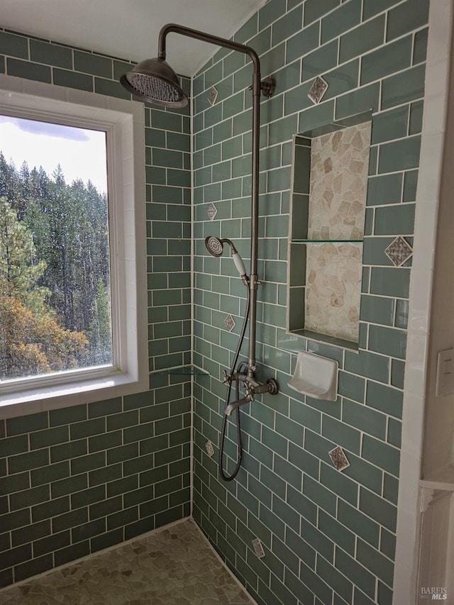 bathroom with a wealth of natural light and a tile shower