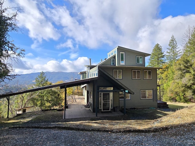 rear view of house featuring a deck with mountain view