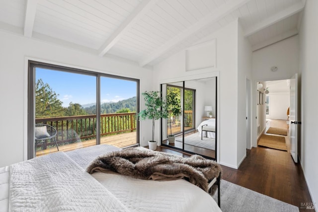 bedroom featuring lofted ceiling with beams, baseboards, wood finished floors, and access to exterior