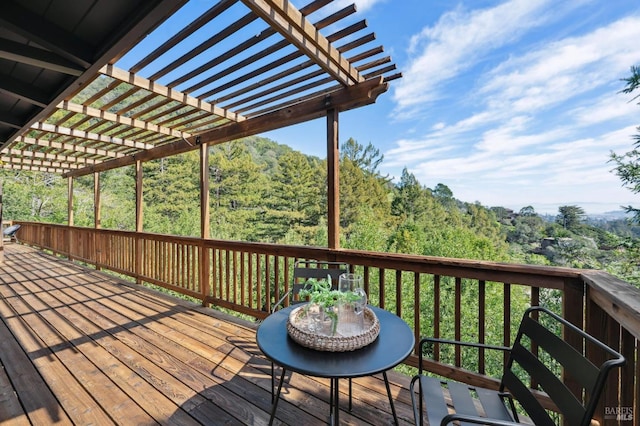 wooden terrace with a forest view and a pergola