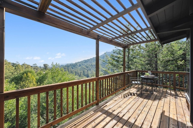 deck with a pergola and a wooded view