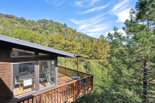 wooden deck featuring a view of trees