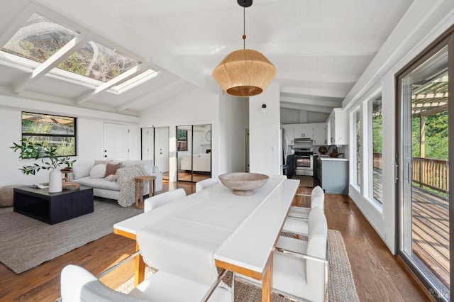 dining space featuring dark wood-style floors, vaulted ceiling with skylight, and plenty of natural light