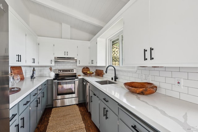 kitchen with tasteful backsplash, vaulted ceiling with beams, stainless steel appliances, under cabinet range hood, and a sink