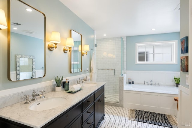 bathroom featuring a stall shower, visible vents, a garden tub, and a sink