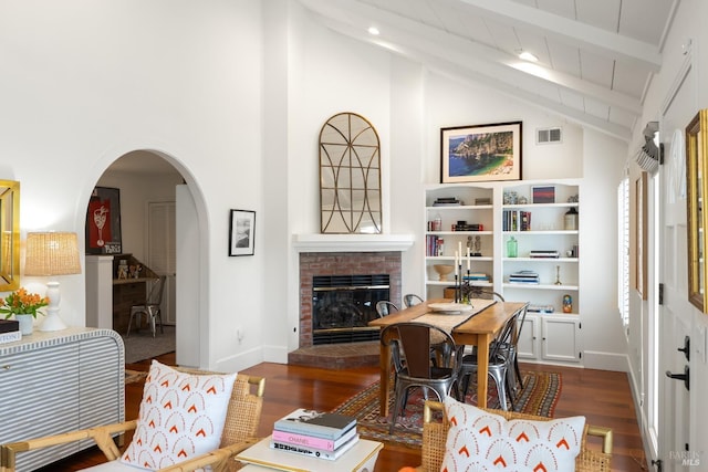 interior space featuring dark wood-type flooring, arched walkways, visible vents, and a fireplace