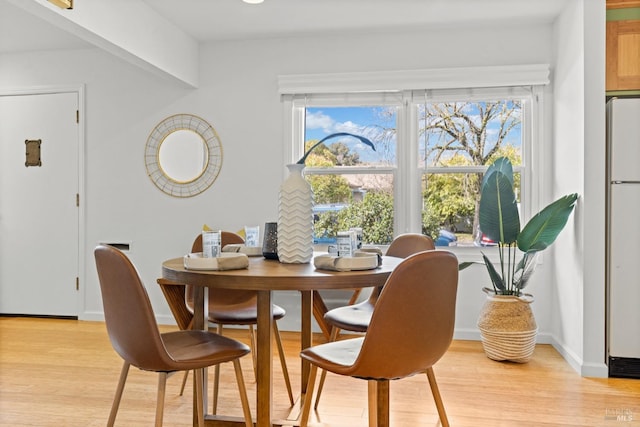 dining room with baseboards and light wood finished floors