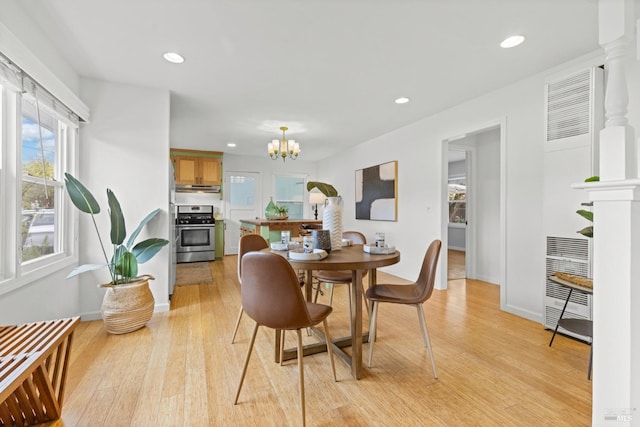 dining area featuring light wood finished floors, a notable chandelier, recessed lighting, and heating unit