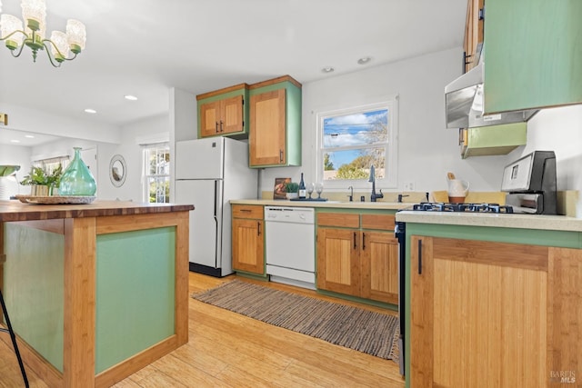 kitchen featuring white appliances, recessed lighting, light countertops, light wood-type flooring, and a chandelier