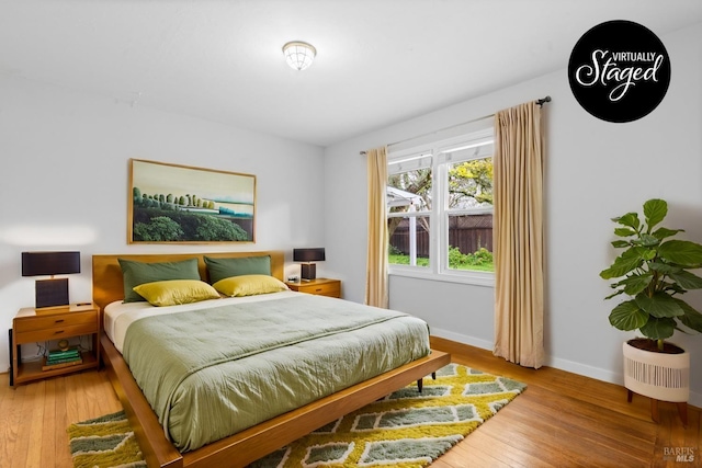 bedroom featuring baseboards and wood finished floors