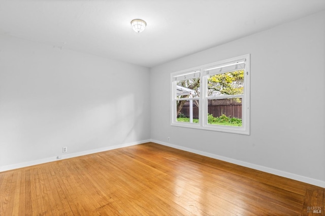 spare room featuring light wood-type flooring and baseboards