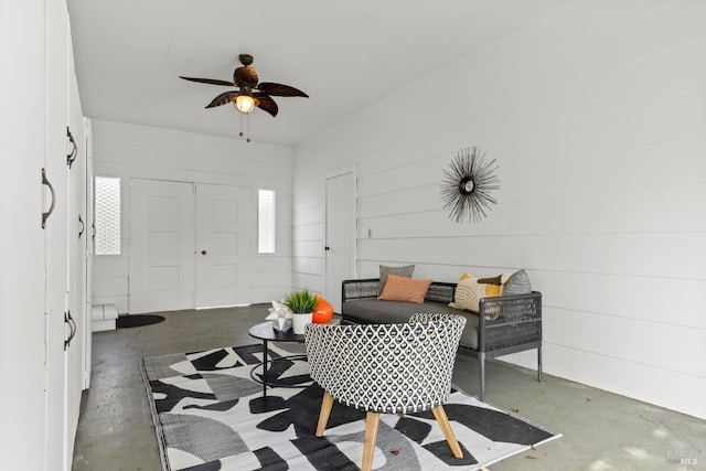 foyer entrance featuring a ceiling fan and concrete flooring