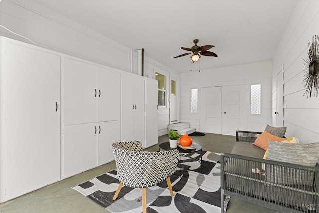 living area featuring a ceiling fan and concrete flooring