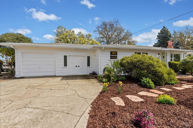 view of front of house with a garage, a chimney, and driveway