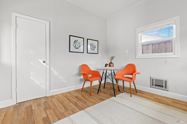 living area with visible vents, baseboards, and wood finished floors