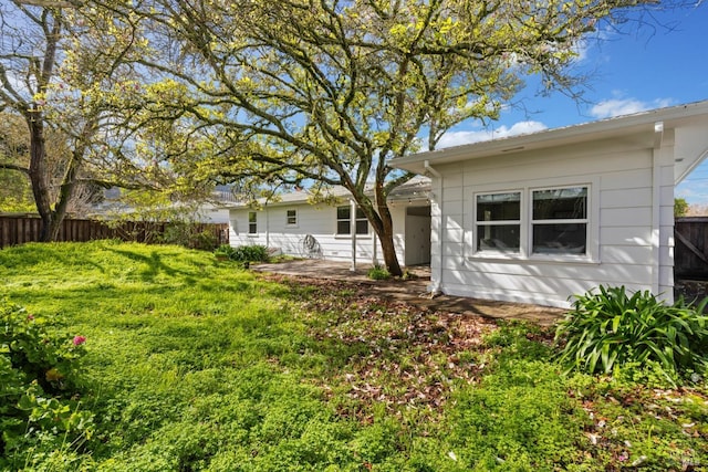 back of house featuring a patio, fence, and a lawn